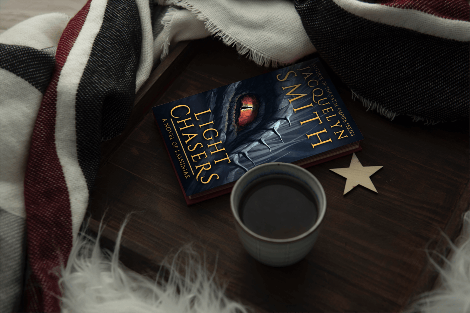 Light Chasers the World of Lasniniar Book 1 paperback with coffee and cozy blankets